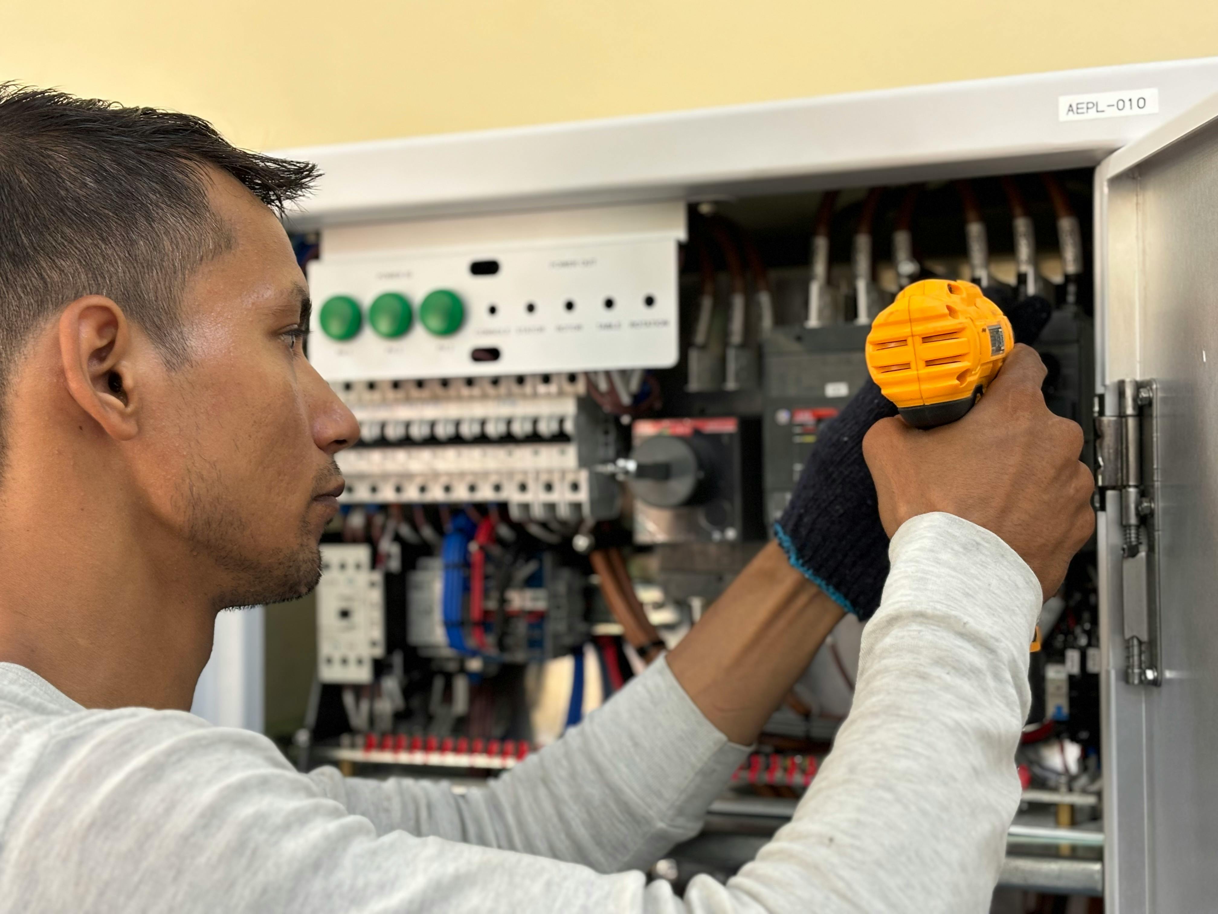 Electrician fitting and testing equipment on a customer site