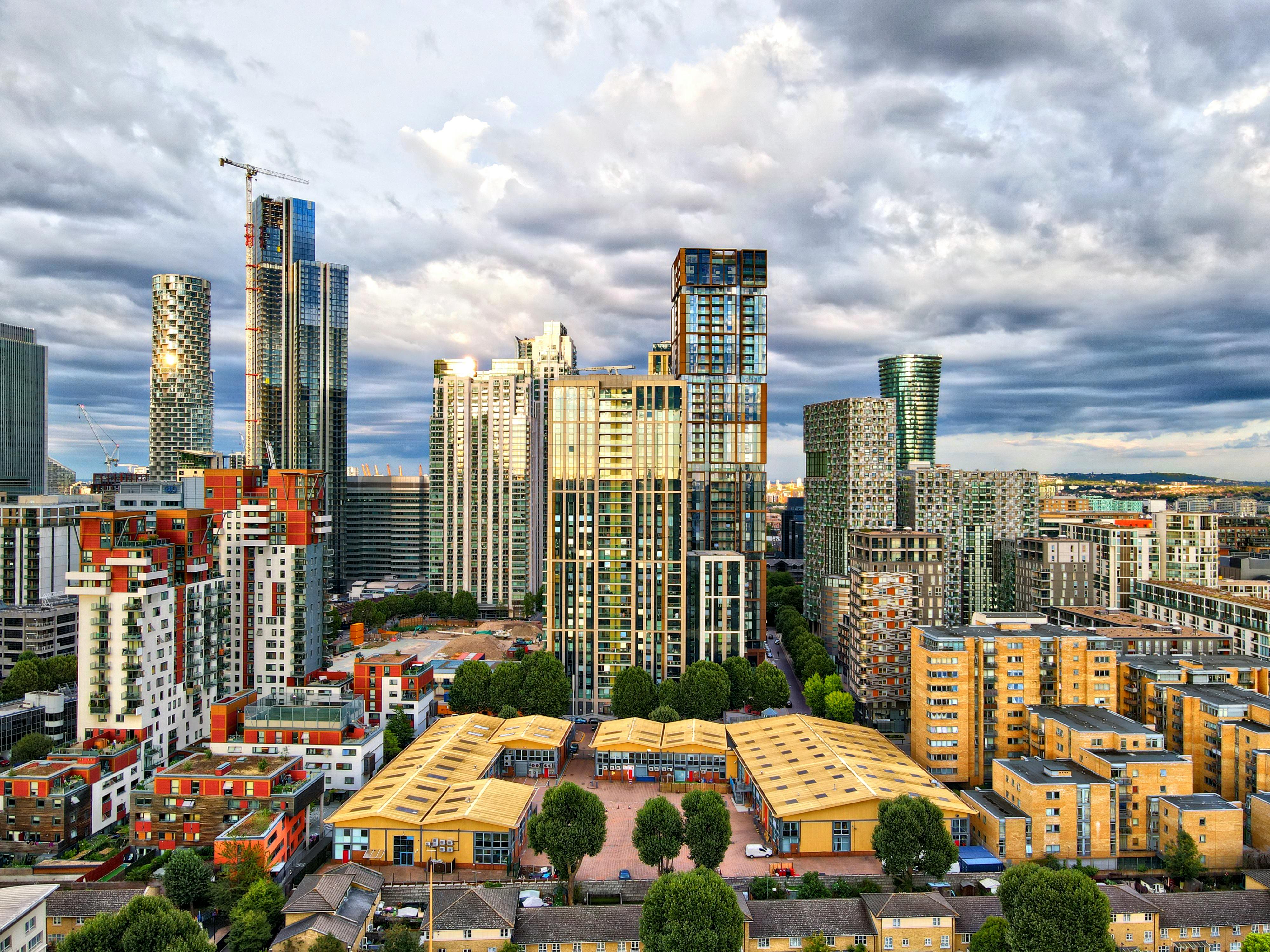 Modern apartment buildings lining a quiet street in Canning Town at dusk