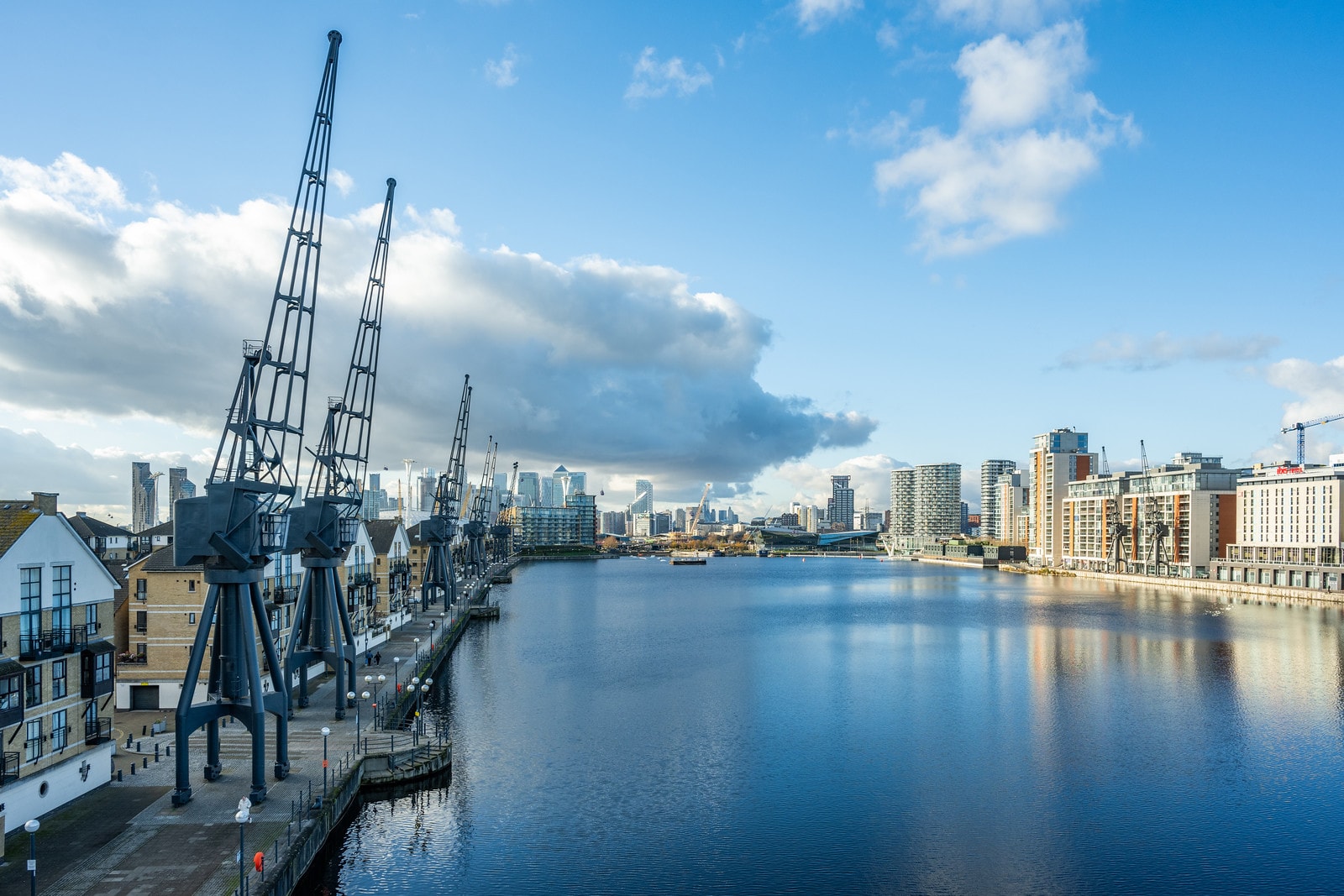 Royal Docks waterfront with the Canary Wharf skyline beyond at sunset
